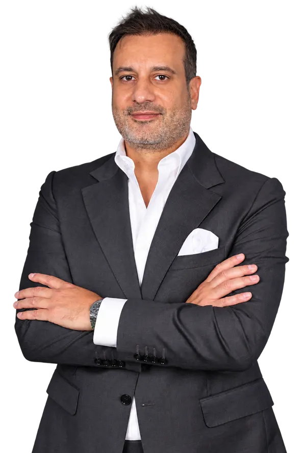 Loai Al Fakir in a charcoal suit, standing with his arms folded